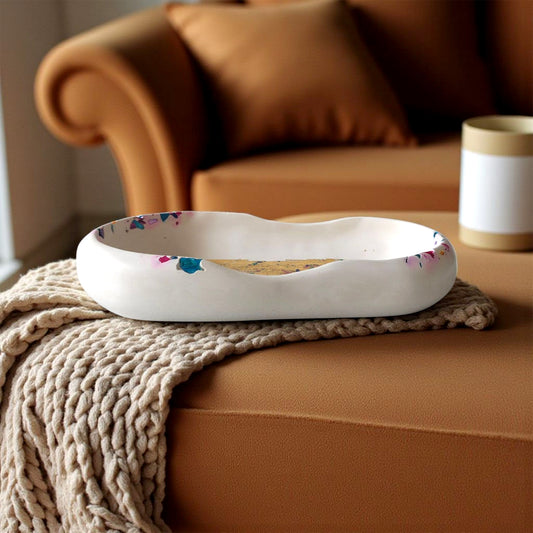 Decorative bowl with floral patterns on a brown sofa with a beige blanket